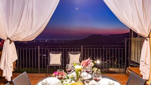 A table set for two with a view of a cityscape at dusk. - Villa Elena 9 1 in Coli (Massarosa)