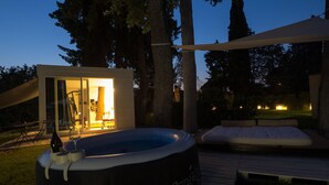 A hot tub on a deck with a glass-enclosed room and a sofa. - La Casa Di Nan 8 in Forli (Forlì)