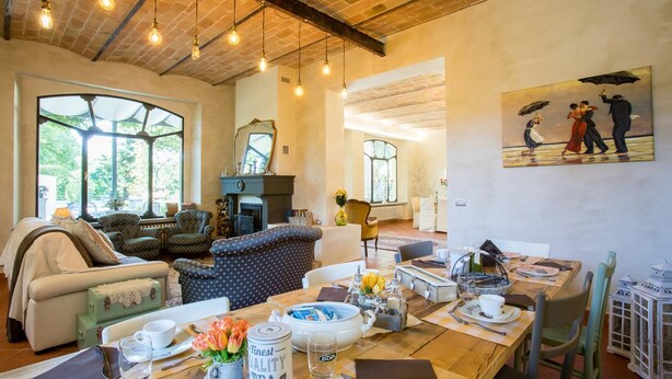 A cozy living room with a fireplace, comfortable seating, and a dining area with a table set for two. - La Casa Di Nan 8 in Forli (Forlì)
