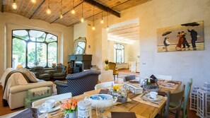 A cozy living room with a fireplace, comfortable seating, and a dining area with a table set for two. - La Casa Di Nan 8 in Forli (Forlì)