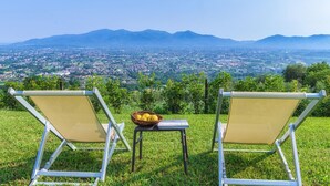 Two lawn chairs facing a scenic view of a city and mountains. - Villa Primo Sole 22 (Lucca)