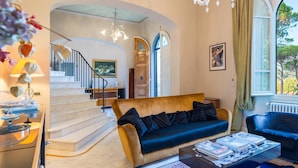 A spacious living room with a sofa, coffee table, and a staircase leading to another level. - Villa Leonardo 30 6 (Figline e Incisa Valdarno)