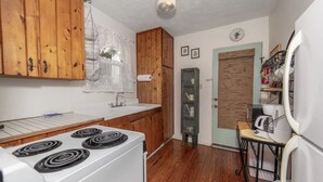 Une cuisine avec des meubles de rangement en bois, une cuisinière blanche, un évier et un réfrigérateur.