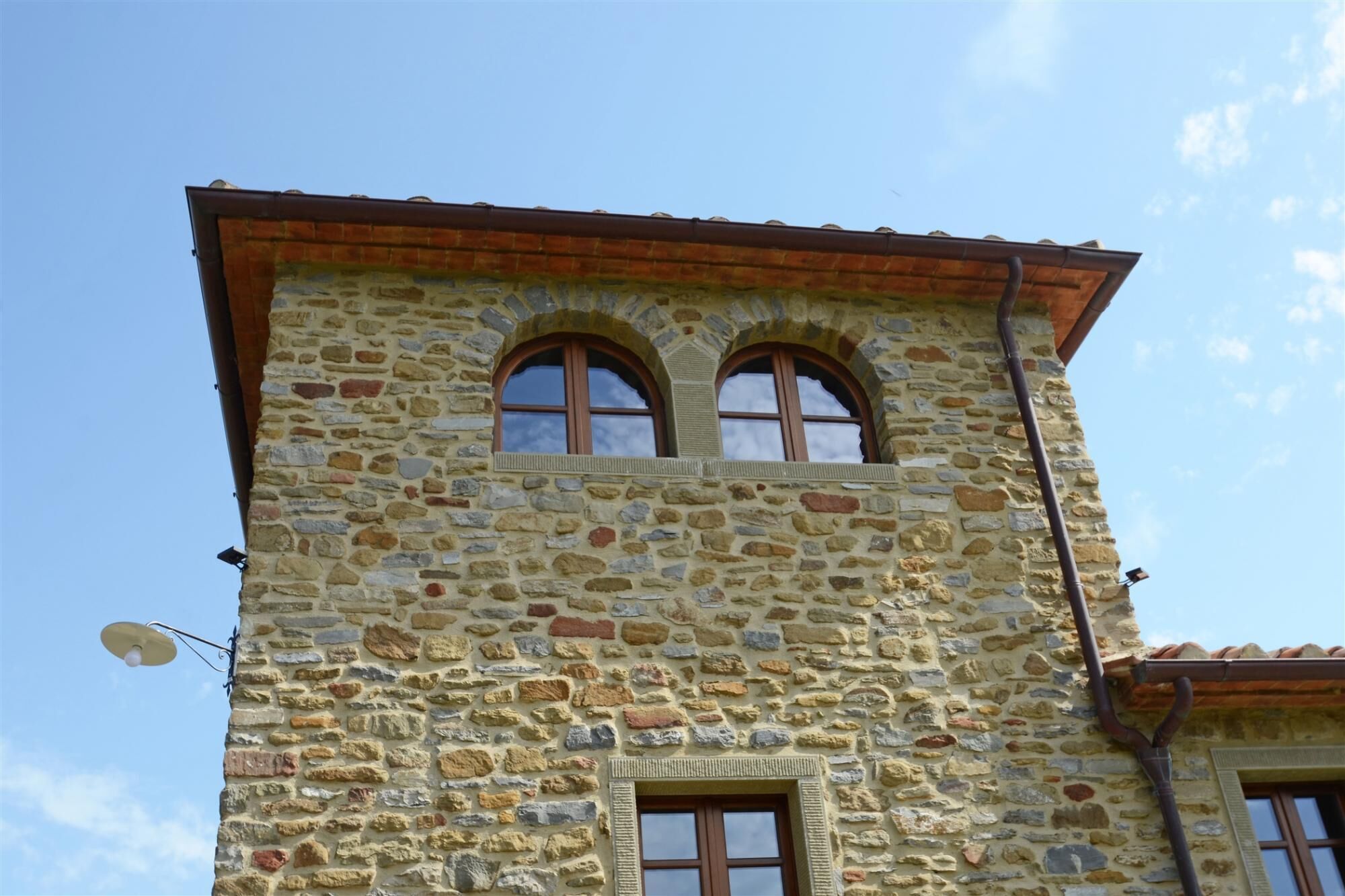 A stone tower with two arched windows and a small balcony.