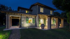 A stone house with a covered patio and arched windows. - Villa Elsa 6 in La Vigna (Villafranca in Lunigiana)