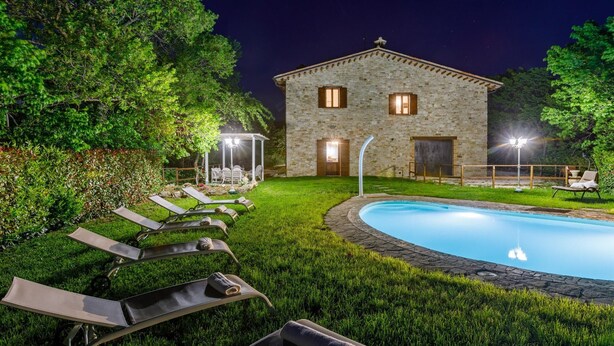 A stone villa with a swimming pool, lounge chairs, and a pergola. - Villa Agostini 10 in Ponte Doccia (Piandimeleto)