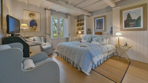 A bedroom with a bed, a desk, a chair, a television, and a bookshelf. - Quercia Felice 17 in Manciano (Manciano)
