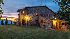 A stone house with a well-maintained lawn and potted plants. - Casale del Viaggiatore 10 (San Casciano dei Bagni)