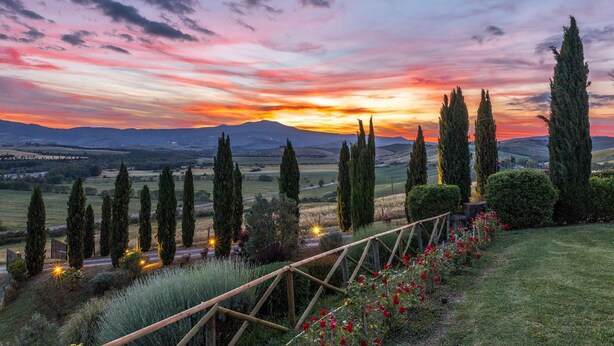 A landscape with a sunset, cypress trees, and a wooden fence. - Casale del Viaggiatore 10 (San Casciano dei Bagni)