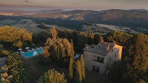 A stone villa with a swimming pool surrounded by trees, overlooking a valley. - Podere Orcio 10 in Volterra (Volterra)