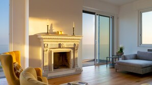 A modern living room with a fireplace, a sofa, a chair, and a balcony with a glass door. - Villa Scirocco 10 2 in Pieve Ligure (Pieve Ligure)