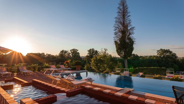A pool area with lounge chairs and a clear view of the surrounding greenery. - Antica Villa Merelli 24 (Monte San Savino)