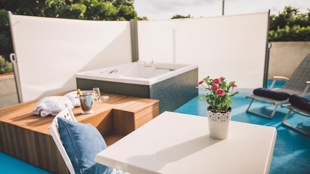 A modern outdoor pool area with a hot tub, lounge chairs, and a table with a potted plant. - Tp-e974-ciav0at - Casale Dom 16 (Marsala)