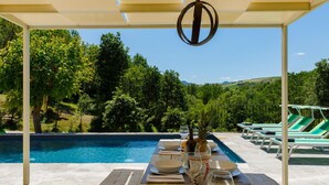 An outdoor dining area with a pool, surrounded by lush greenery and a clear sky. - Fc-f139-mini0at - Villa Mia 6 (Mercato Saraceno)