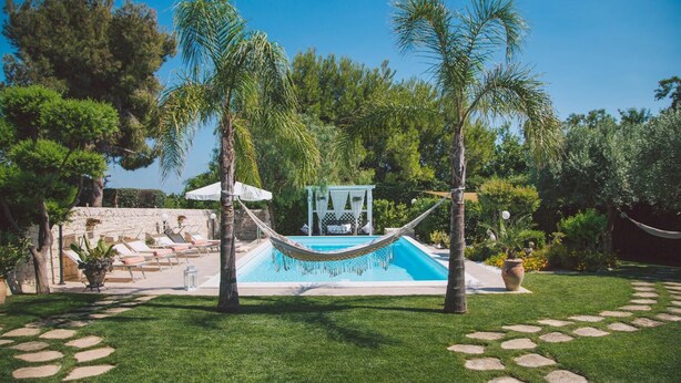 A pool area with a hammock, lounge chairs, and a small gazebo. - Rg-e366-sp460at - Villa Ferradina 4 2 (Ispica)