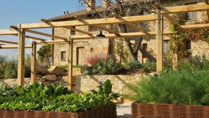 Een stenen gebouw met een houten pergola ervoor.