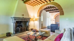 A spacious living room with a fireplace, comfortable seating, and an arched ceiling. - Ar-f628-mssa0at - Villa Pucci 12 (Monte San Savino)