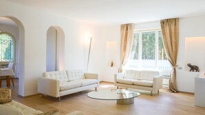 A modern living room with two white sofas, a glass coffee table, and a dining area with a table and chairs. - Rn-h274-pini35at - Villa Sarah 10 2 (Riccione)
