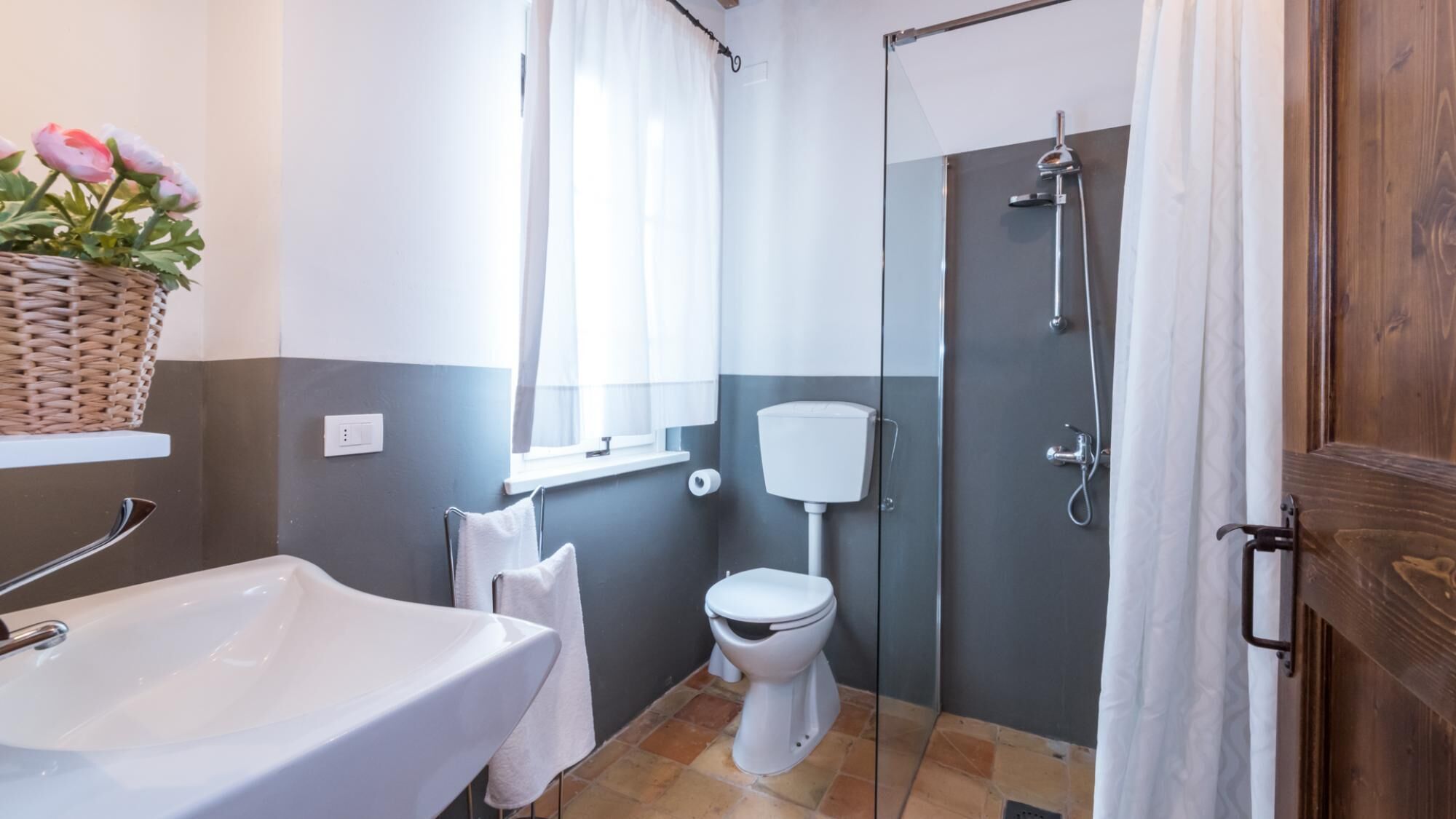 Un baño con lavamanos blanco, inodoro y ducha.