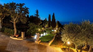 A landscaped garden with pathways, stone structures, and trees at dusk. - Si-g752-sdto0at - Tenuta di Macericca 10 (Poggibonsi)