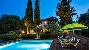 A swimming pool with lounge chairs and an umbrella, surrounded by trees and a stone building. - Si-g752-sdto0at - Tenuta di Macericca 10 (Poggibonsi)