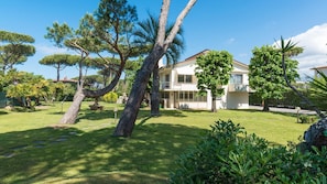 A two-story house with a well-maintained lawn and various trees. - Ms-f023-manz11at - Il Renzito 8 (Montignoso)