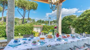 An outdoor dining area with a table set for a meal, surrounded by stone pillars and lush greenery. - Ms-f023-manz11at - Il Renzito 8 (Montignoso)