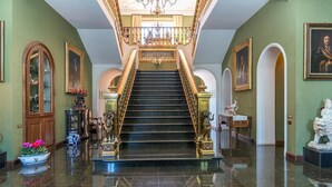 A grand staircase with ornate railings and a chandelier, leading to an upper floor. - Pg-c990-dfio19at - Villa Michelangelo 14 (Corciano)