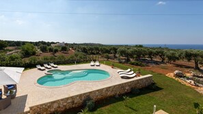 A swimming pool with lounge chairs, surrounded by a stone deck, with a view of the sea and olive trees. - Le-c336-sp2140at - Villa Sanssouci 8 (Castrignano del Capo)