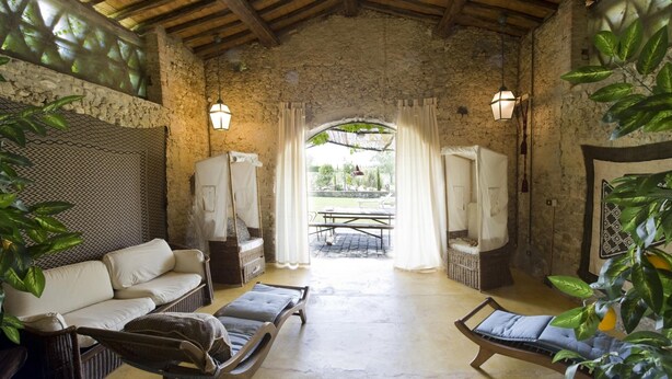 A rustic room with a stone wall, a wooden ceiling, a sofa, a chair, a table, and a canopy bed. - Fi-m408-snoc0at - Casabianca 12 (Barberino Tavarnelle)