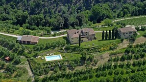 An aerial view of a property with multiple buildings, a swimming pool, and landscaped gardens. - Pi-i046-smin0at - Germagnana 14 (San Miniato)