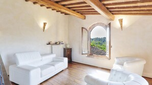A spacious room with a white leather sofa, a white armchair, and a wooden ceiling. - Pi-i046-smin0at - Germagnana 14 (San Miniato)