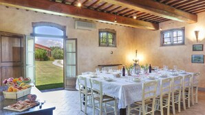 A dining area with a table set for six, surrounded by white chairs. - Pi-i046-smin0at - Germagnana 14 (San Miniato)