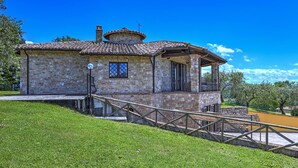 A stone building with a tiled roof, a balcony, and a small staircase leading up to it. - Tr-f457-mcas0as - Colle del Sole 7 1 (Montecastrilli)