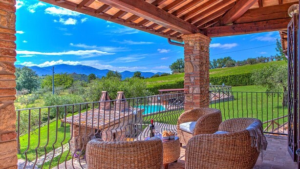 A covered outdoor seating area with wicker furniture, a pool, and a view of mountains. - Tr-f457-mcas0as - Colle del Sole 7 1 (Montecastrilli)