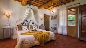 A bedroom with a bed, a canopy, a wooden door, and a window with curtains. - Villa Zaca 6 in Rio Marina (Rio)