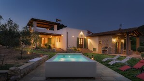 A modern house with a swimming pool, outdoor seating, and a stone fireplace. - Villa Zaca 6 in Rio Marina (Rio)
