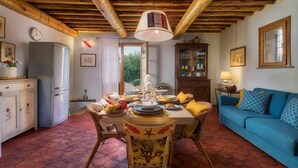 A cozy dining area with a wooden table set for a meal, surrounded by wicker chairs. - Villa Zaca 6 in Rio Marina (Rio)