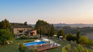 A stone house with a swimming pool, deck chairs, and umbrellas. - Masso Delle Fanciulle 14 (Pomarance)