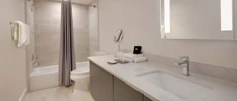 A modern bathroom with a bathtub, toilet, and sink.