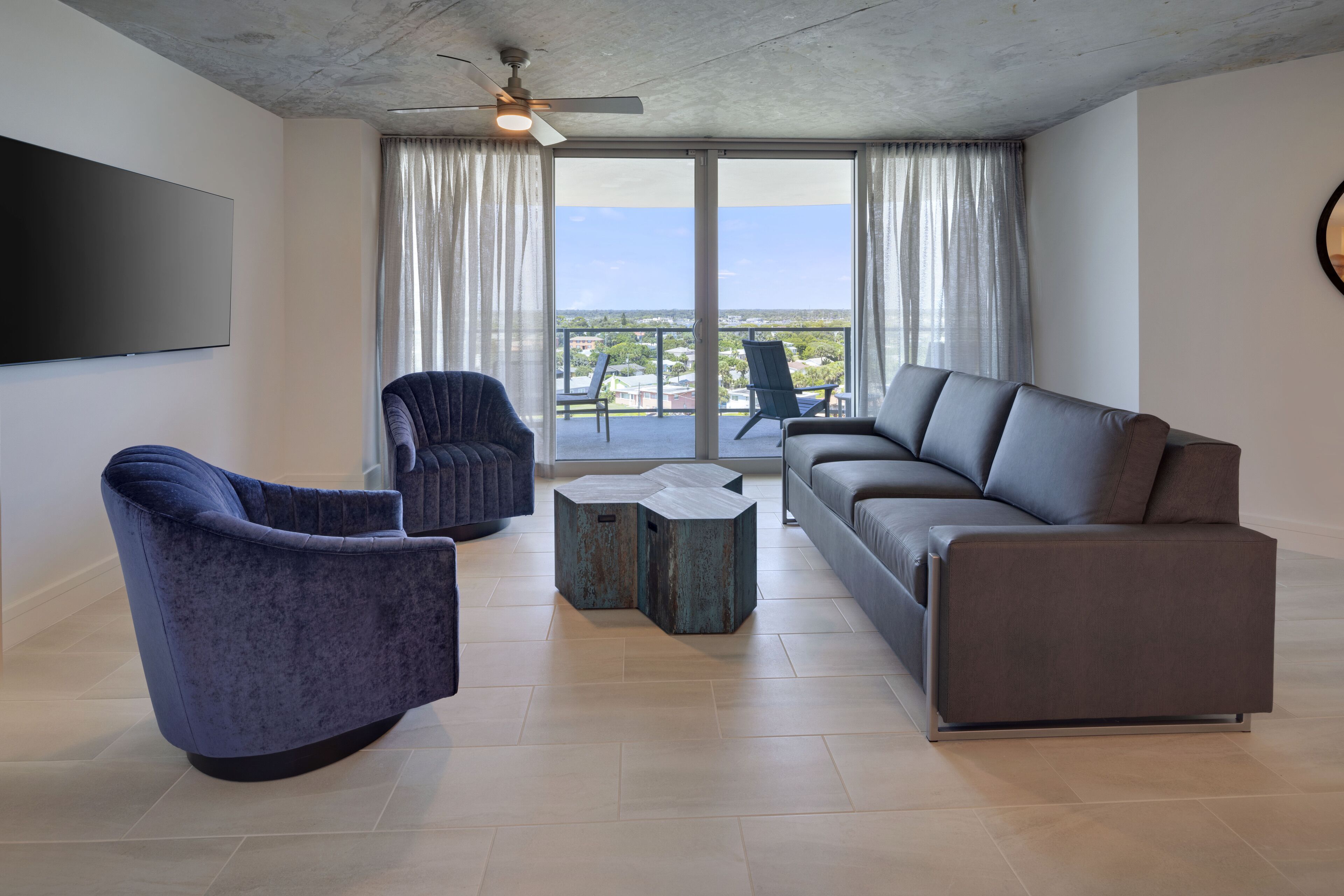 A modern living room with a grey sofa, a blue armchair, and a small coffee table.