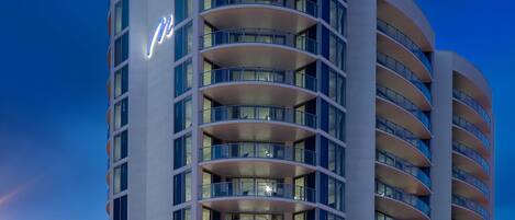 A multi-story hotel with a modern design, featuring balconies on each floor.