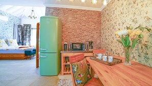 A modern living room with a green refrigerator, a wooden dining table, and a kitchen area with a microwave and coffee maker. - 8 | La Gomera Deluxe | Apartment, 1-3 Persons. Fantastic view, great terrace (La Calera)