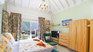 A bedroom with a bed, a TV, a wardrobe, and a balcony with curtains. - 8 | La Gomera Deluxe | Apartment, 1-3 Persons. Fantastic view, great terrace (La Calera)