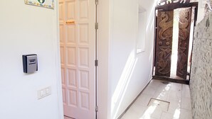 A hallway with a door marked "8", a "No Fum" sign, a "Casa" sign, a security keypad, and a doormat with "COME" written on it. - 8 | La Gomera Deluxe | Apartment, 1-3 Persons. Fantastic view, great terrace (La Calera)