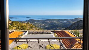 Vista da un balcone su un paesaggio costiero con cielo sereno.
