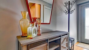 A wooden console table with decorative glass vases and a mirror.