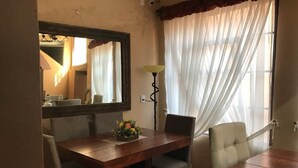 A dining area with a wooden table, two chairs, a mirror, and a lamp. - House of Stairs, Pátzcuaro, Michoacán (Pátzcuaro)