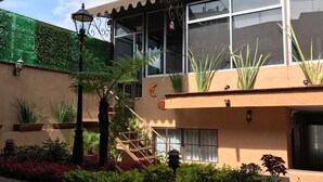 A building with a beige facade, large windows, and a balcony with potted plants. - House of Stairs, Pátzcuaro, Michoacán (Pátzcuaro)