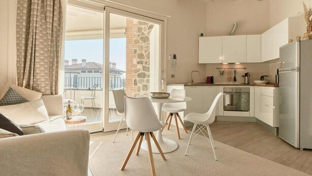 Un appartement moderne doté d’un balcon, d’un coin repas et d’une cuisine.